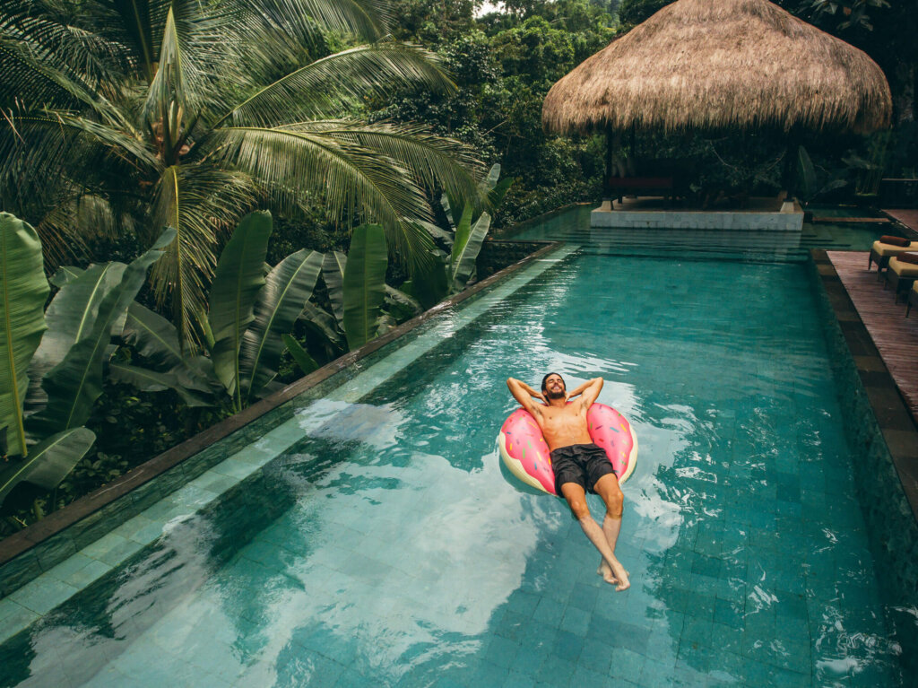 Mann auf Luftmatratze im Pool