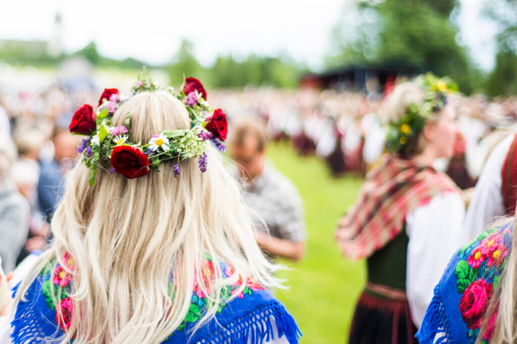 Schweden, Kultur - Mitsommar Fest mit vielen Menschen von hinten mit Blumenkränzen in den Haaren
