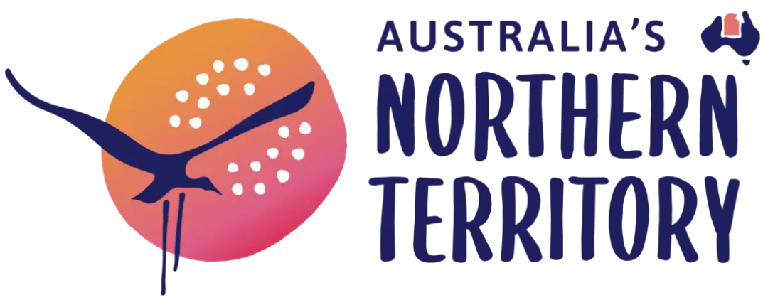 Logo für das australische Nordterritorium mit einem stilisierten Vogel vor einem orangefarbenen und rosafarbenen kreisförmigen Hintergrund mit weißen Punkten und dem fettgedruckten Text 