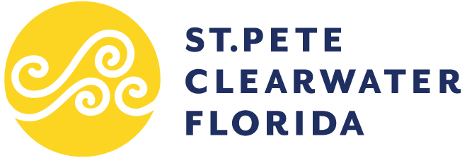 Logo für St. Pete Clearwater, Florida. Es besteht aus einem gelben Kreis mit weißen, wirbelnden Wellenmustern auf der linken Seite und einem kräftigen, marineblauen Schriftzug auf der rechten Seite, der lautet: ST. PETE CLEARWATER FLORIDA.